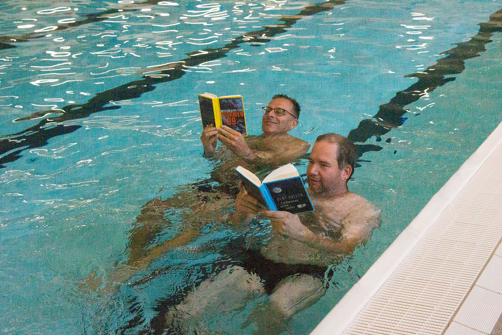 Svøm en bog i Thyregod, som de to mænd her - flydende i vandet og en bog op foran sig