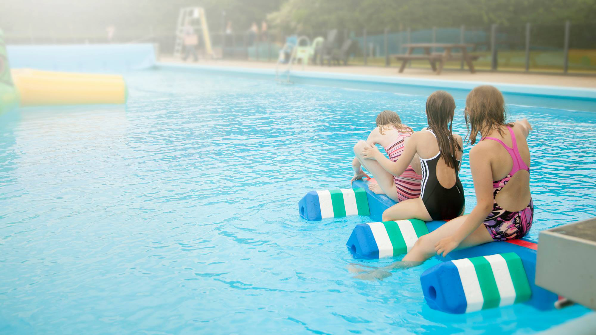 Jelling Friluftsbad 3 piger leger på skumdyr i bassinet