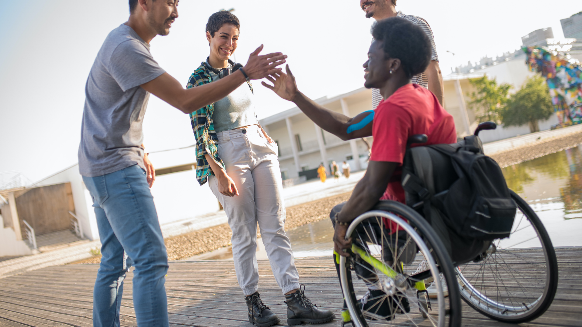 Person i kørestol, der giver highfive til sine venner